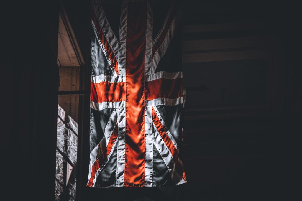 A dramatic portrayal of the Union Jack flag inside a dimly lit room.