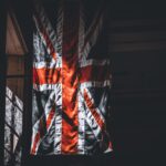 A dramatic portrayal of the Union Jack flag inside a dimly lit room.