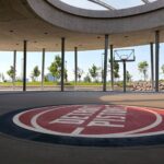 An outdoor basketball court featuring Detroit Pistons branding under a modern canopy.