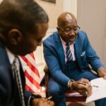 Two businessmen reviewing a contract document in an office setting.