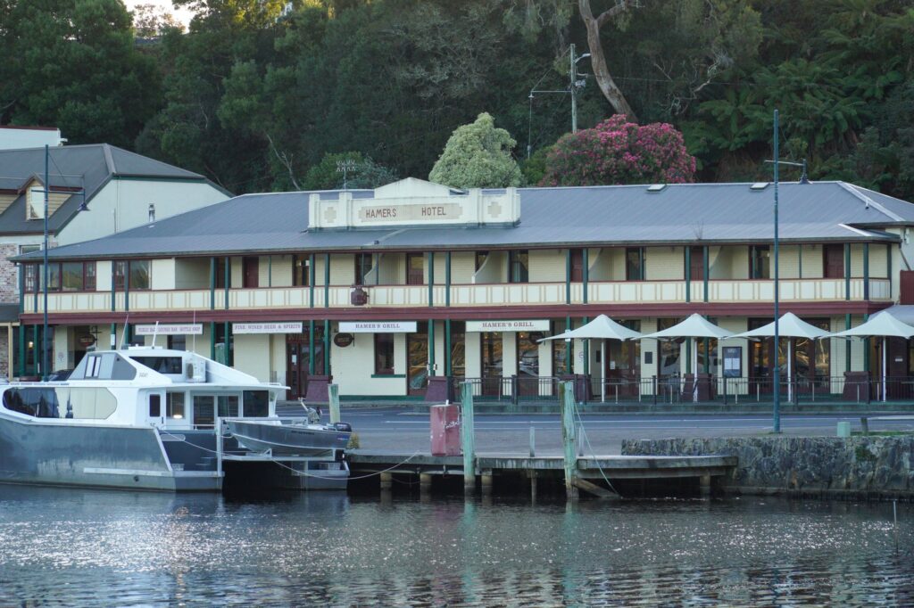 Hamers Hotel with boats docked on the scenic waterfront in Strahan, Tasmania.