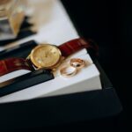 Close-up of a classic watch with gold rings on piano keys, symbolizing elegance and timeless beauty.