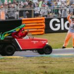 Joyful celebration at Formula 1 event in Interlagos, featuring a driver in a red buggy with a Brazilian flag.