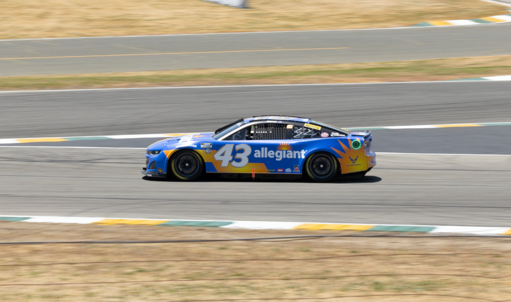 Blue race car speeding on track during a competition event.