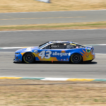 Blue race car speeding on track during a competition event.