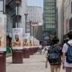 Bustling urban street in Chiyoda City, Tokyo with pedestrians and Final Fantasy ads.