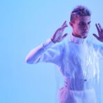 Futuristic portrait of a man in a studio with blue lighting, exuding cybernetic vibes.