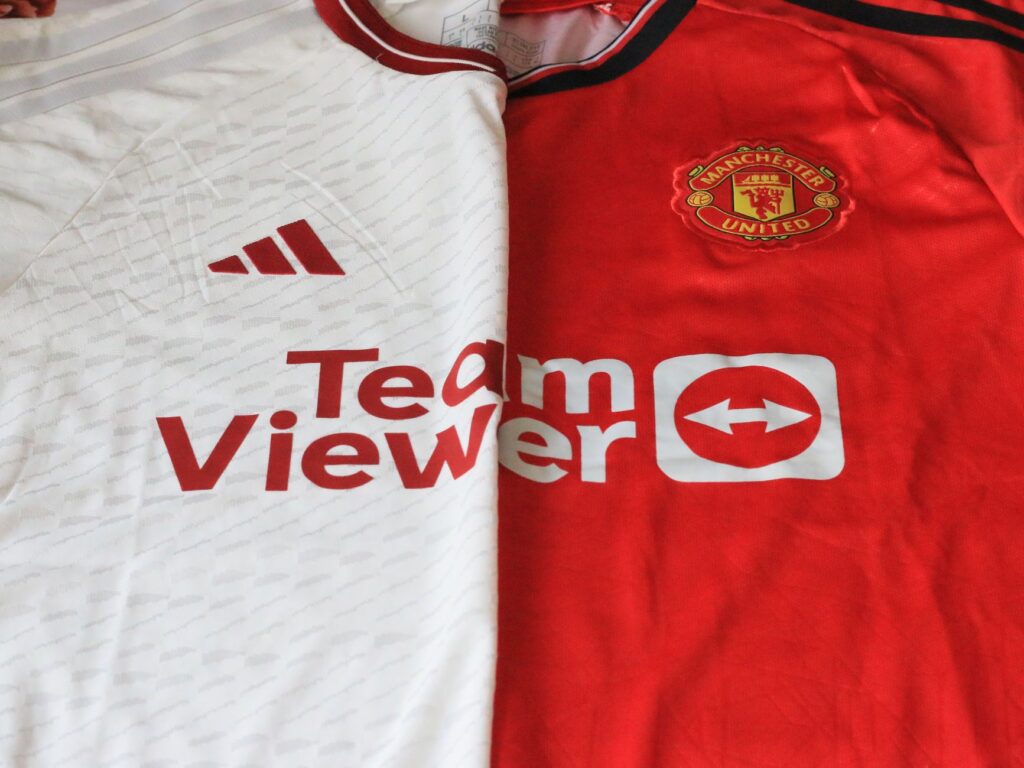 Close-up of Manchester United 2023 jerseys showcasing red and white designs.