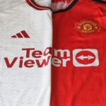 Close-up of Manchester United 2023 jerseys showcasing red and white designs.