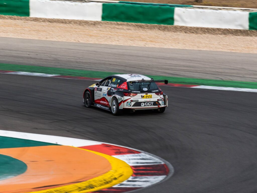 High-speed race car taking a sharp turn at Portimão Circuit, Portugal.