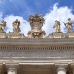 Close-up of statues and architecture at St. Peter's Basilica, Vatican City under a clear blue sky.