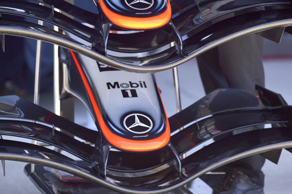 Detailed view of a Formula 1 car's front wing with Mercedes-Benz logos at Indianapolis.