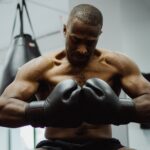 Athlete preparing for an intense training session in the gym, wearing boxing gloves and focusing on fitness.