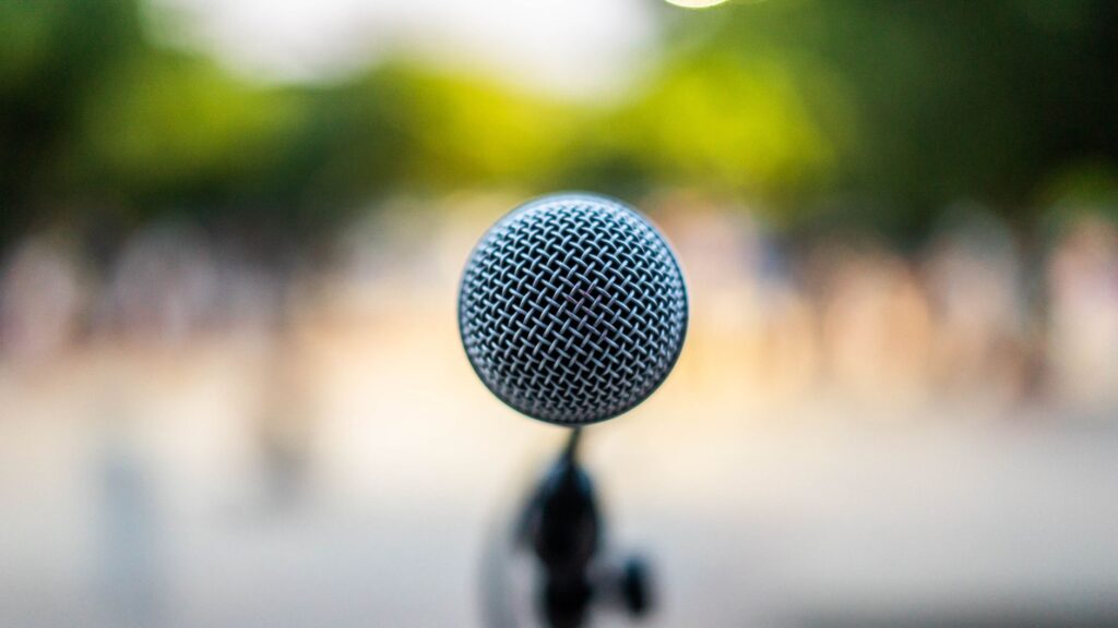 Soft focus of modern microphone located on stage during music concert in park