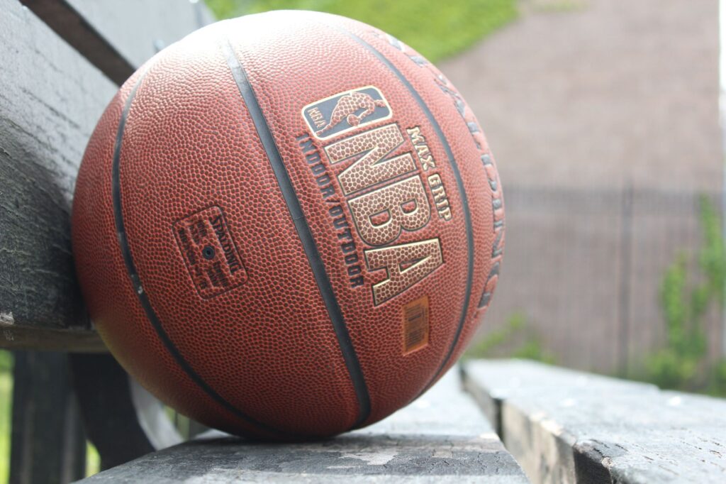 A detailed image showcasing a basketball resting on a park bench, highlighting texture and outdoor setting.