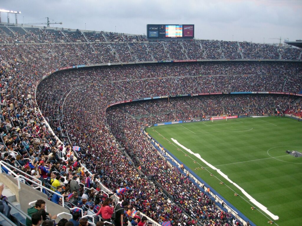 A packed stadium with enthusiastic fans watching an exciting soccer match.