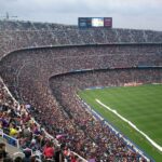 A packed stadium with enthusiastic fans watching an exciting soccer match.