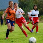 Action-packed women's soccer match showing players competitively engaging on the field.
