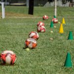 Soccer training equipment arranged on grass in Brasília, Brazil, featuring balls and cones.