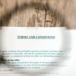 Magnifying glass focusing on terms and conditions document on wooden surface.