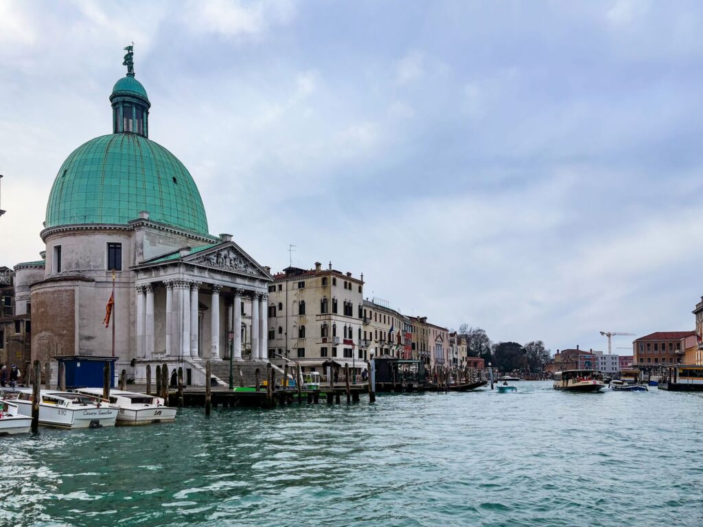 Explore the stunning architecture along Venice's Grand Canal with its iconic dome and boats.