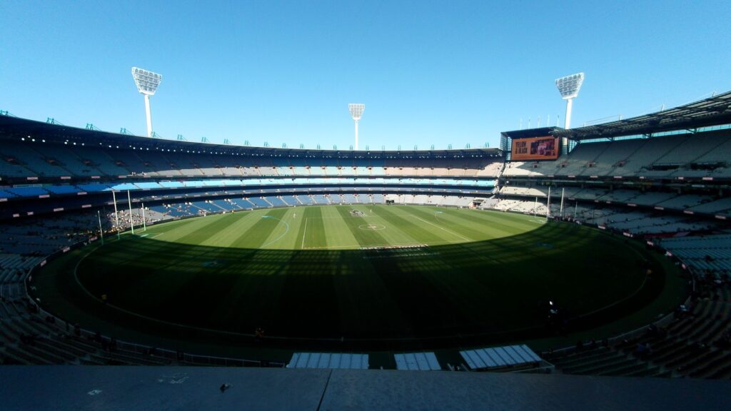 A wide-angle view of the Melbourne Cricket Ground, showcasing its expansive field and seating.