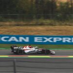Dynamic shot of a Haas F1 car racing on a track at Spa-Francorchamps, Belgium.