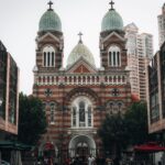 Saint Joseph Cathedral stands prominently against a backdrop of towering modern buildings, combining architectural styles.