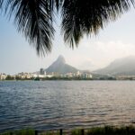 Panoramic view of Pedra da Gávea framed by palm trees in Rio de Janeiro, Brazil.