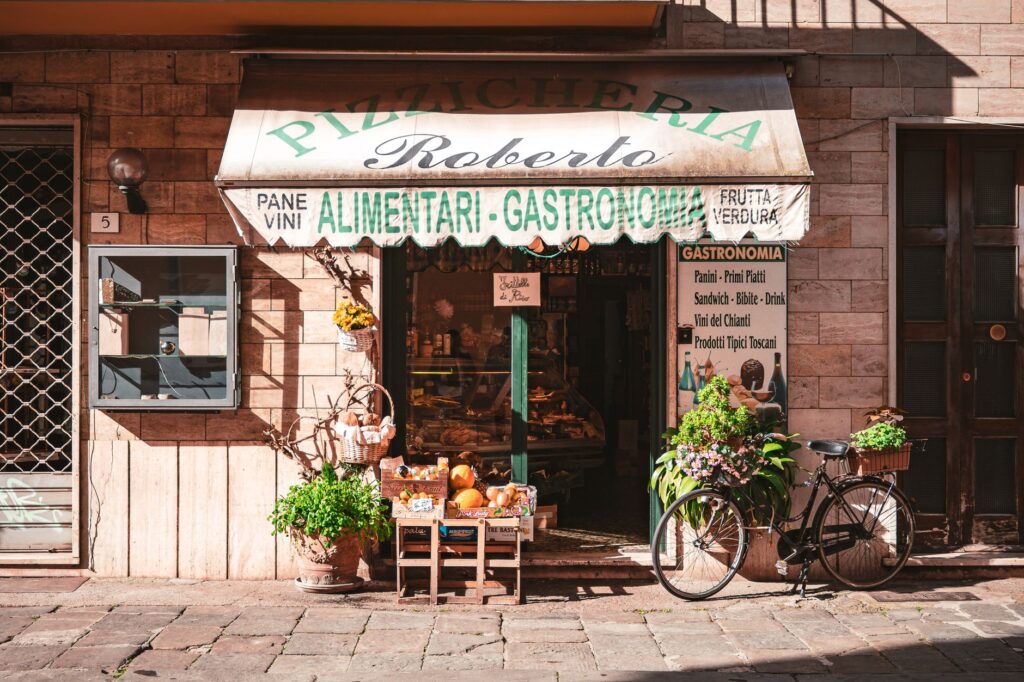 A quaint Italian grocery store with fresh produce and a vintage bicycle outside, offering local delicacies.