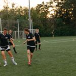 Women soccer players practice on a field at sunset, showcasing teamwork and athleticism.