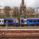ScotRail train captured by the iconic Scott Monument in Edinburgh, highlighting urban transport.