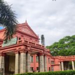 Historic Sheshadri Iyer Memorial Hall amidst lush greenery in Bangalore, India.