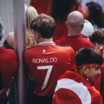 Football enthusiasts gather in team jerseys, celebrating their passion for the game outdoors.