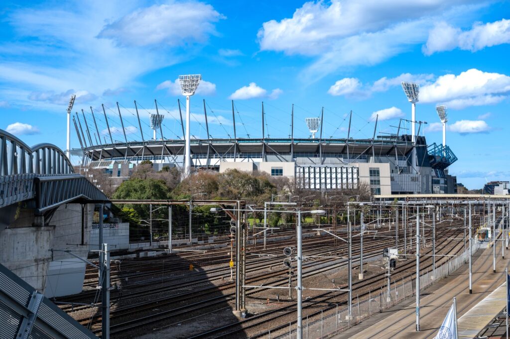 A sunny view of the Melbourne Cricket Ground and nearby railway tracks in Richmond, Australia.