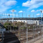 A sunny view of the Melbourne Cricket Ground and nearby railway tracks in Richmond, Australia.