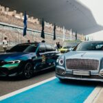 Elegant lineup of luxury cars at a racing event in Greater Noida, India, showcasing Bentley and BMW models.