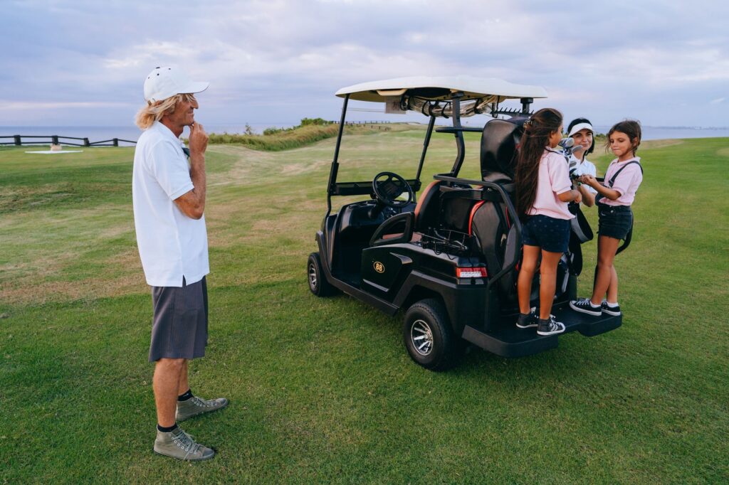 Group of people enjoying a day at the golf course with a golf cart.