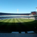 A wide-angle view of the Melbourne Cricket Ground, showcasing its expansive field and seating.