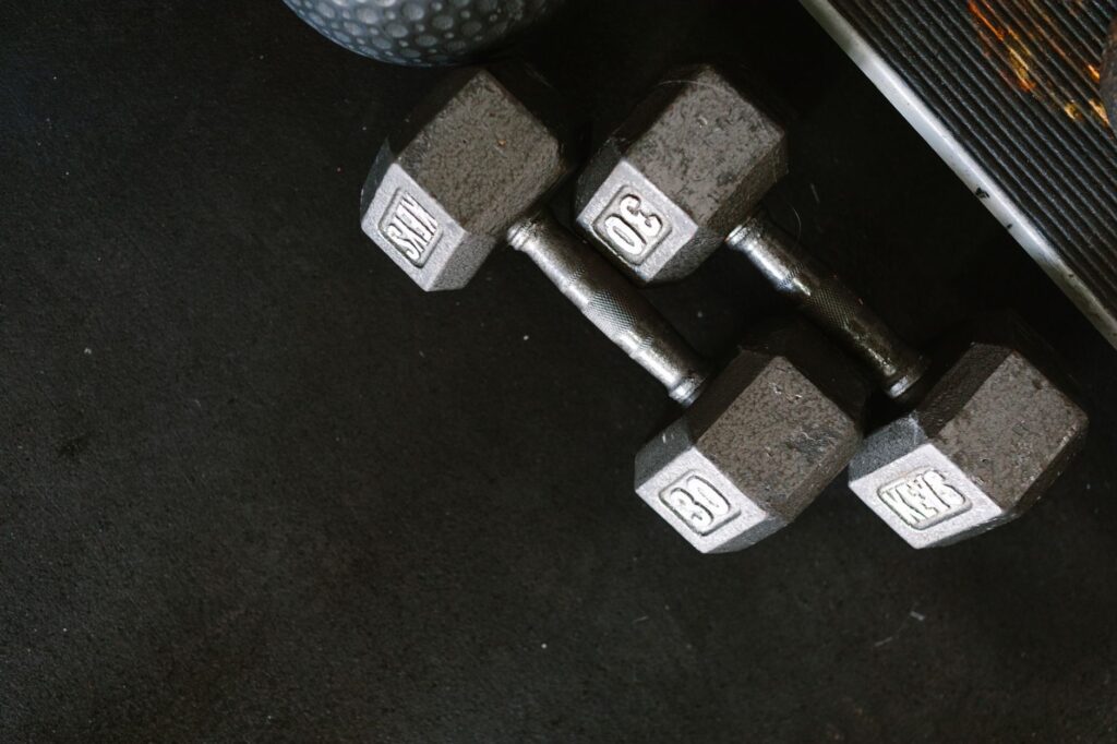 Close-up of black dumbbells on a gym floor, perfect for fitness themes.