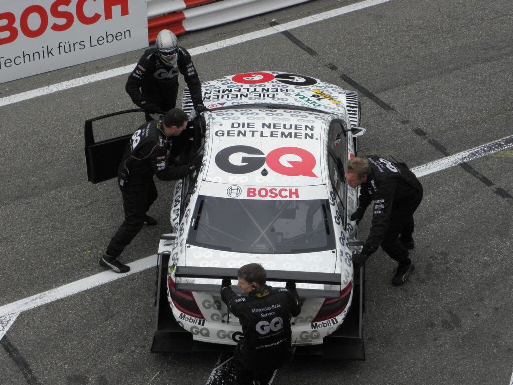 A racing team pushes a Mercedes-Benz race car on the track at Zandvoort.