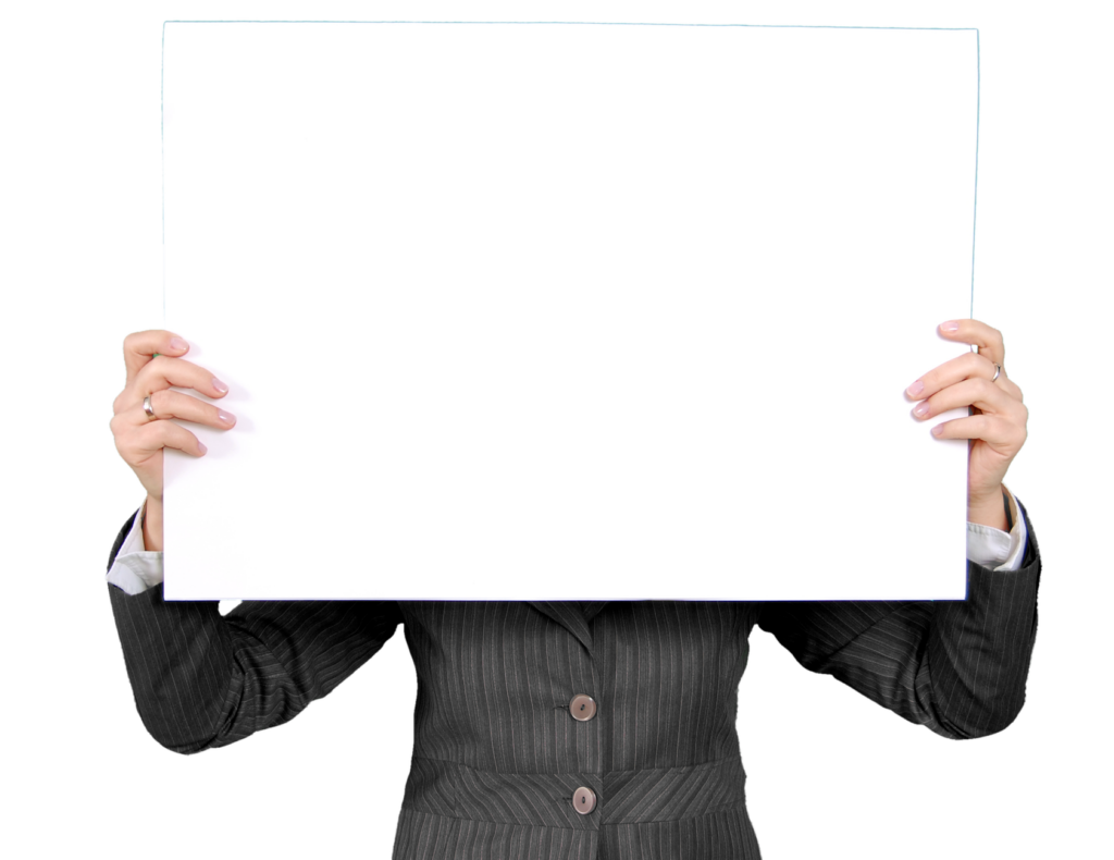 An individual in a formal blazer holds a blank whiteboard, ideal for custom messages.