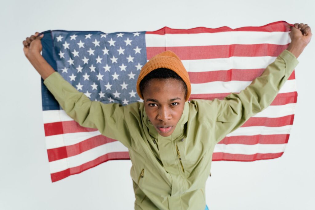Teen boy holding the American flag, symbolizing patriotism and freedom.