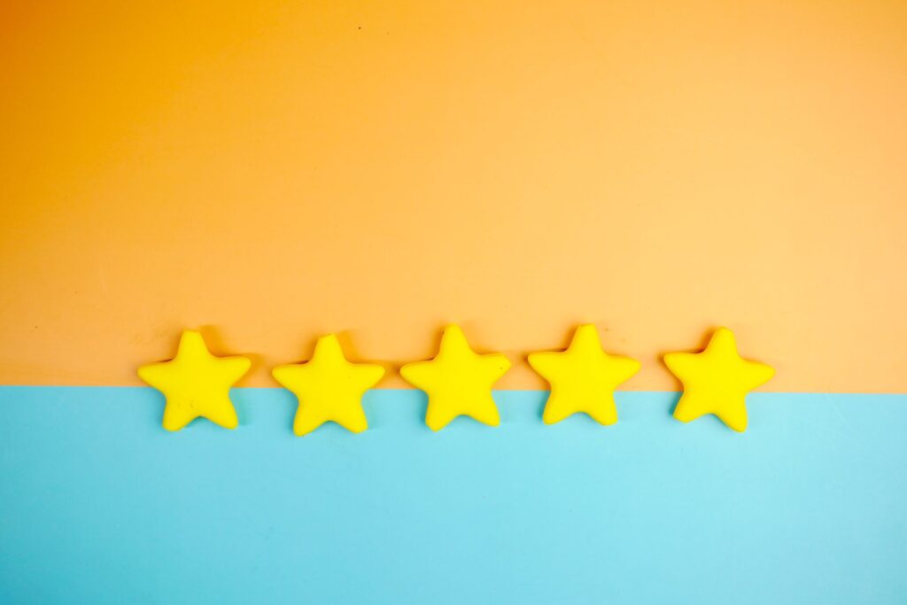 Bright yellow stars arranged on a vivid orange and blue background with copy space.