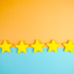 Bright yellow stars arranged on a vivid orange and blue background with copy space.
