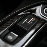 Detailed close-up of a modern car's gear shift indicator showcasing technology and design.