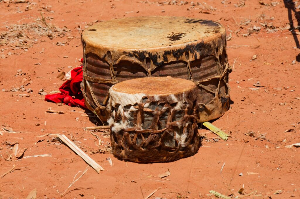 Two African drums resting on red earth in Chipinge, Zimbabwe.