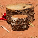 Two African drums resting on red earth in Chipinge, Zimbabwe.