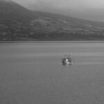 Fishing boat in calm waters of Carlingford Lough, Ireland on a misty day.